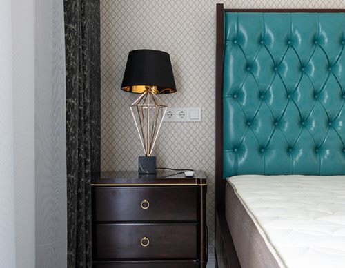 Canva - Lamp on bedside table against bed in house_ Canva - Lamp on bedside table against bed in house_